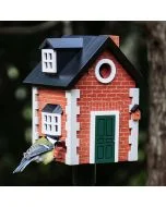 Koolmees bij de voederopening van de Multiholk Brick Cottage van Wildlife Garden, een houten nestkast en voederhuis met rode baksteenlook, groene deur en zwart dak.