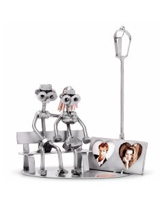 Handgemaakte Hinz & Kunst sculptuur van een verliefd paar op een bankje met fotohouder voor twee foto's. Persoonlijk cadeau voor huwelijk of jubileum.