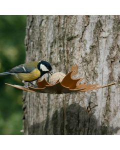 Bruine Leaf Me wandvoederschaal van metaal aan een boom, met een koolmees die eet van een vetbol in de bladvormige houder.