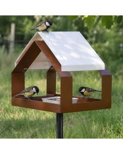The Barn voederhuis op paal in bruin metaal met wit zadeldak en drie koolmezen bij de voederbak in de tuin.