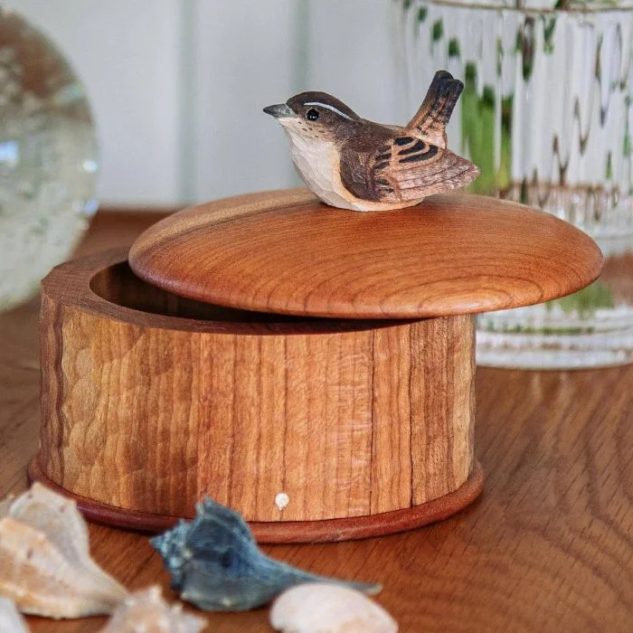 Houten opbergdoos Winterkoning van Wildlife Garden met licht geopend rond deksel en houten winterkoninkje, op een tafel met schelpen en glazen vaas.