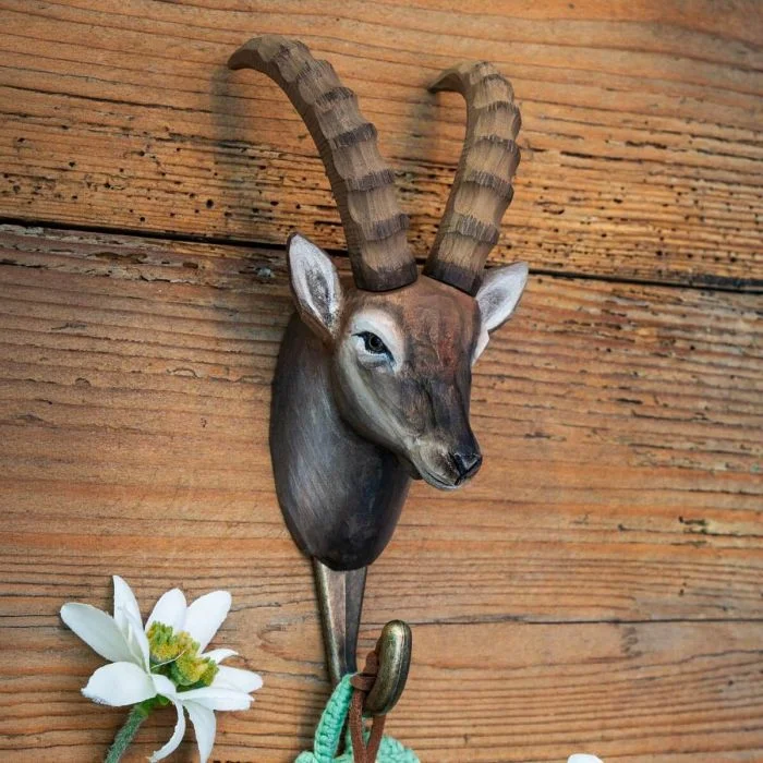 Kledinghaak Alpensteenbok van Wildlife Garden aan een rustieke houten wand, met bruine steenbokkop, lange geribbelde hoorns en metalen haak.