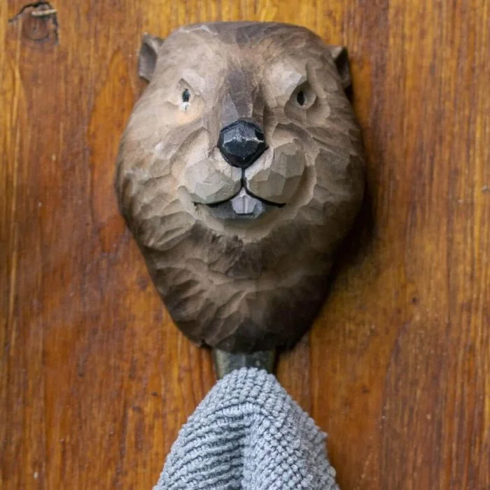 Kledinghaak Bever van Wildlife Garden aan een houten wand, met een bruin gesneden beverkop en een grijze handdoek aan de metalen haak.