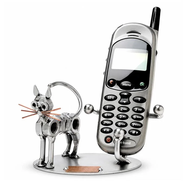 Metalen kat GSM-houder met grote ogen, puntoren en koperkleurige snorharen. 15 x 10 x 9 cm. Praktisch cadeau voor kattenliefhebber.