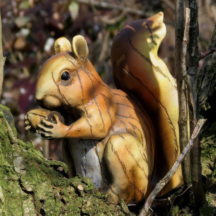 Decoratieve Woodland Friends eekhoorn met noot en grote pluimstaart. Natuurgetrouw vormgegeven en ca. 14 cm hoog. Leuk voor huis of tuin.